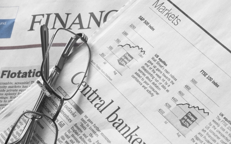 financial newspapers with a pair of glasses on top